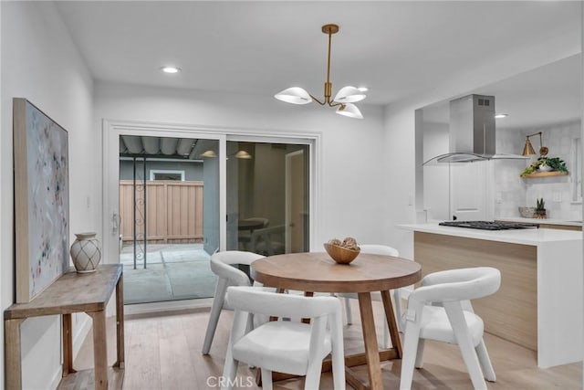 dining area featuring light hardwood / wood-style flooring and a chandelier