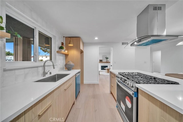 kitchen with sink, light wood-type flooring, appliances with stainless steel finishes, light brown cabinets, and island range hood