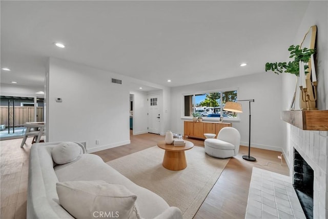 living room featuring light hardwood / wood-style flooring and a fireplace