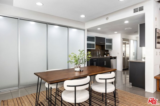 dining area featuring sink and tile patterned flooring