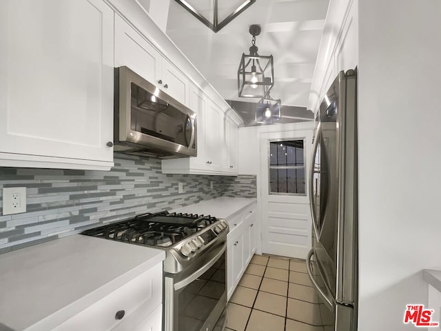 kitchen featuring decorative light fixtures, decorative backsplash, appliances with stainless steel finishes, and white cabinetry