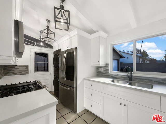 kitchen featuring tasteful backsplash, sink, stainless steel refrigerator, hanging light fixtures, and white cabinets