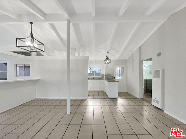 interior space with hanging light fixtures, white cabinets, an inviting chandelier, and light tile patterned flooring