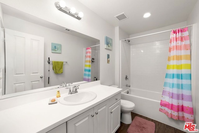 full bathroom with toilet, hardwood / wood-style flooring, vanity, and shower / tub combo with curtain