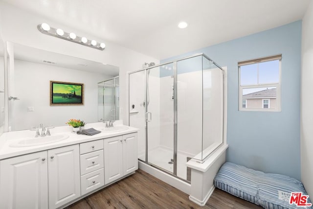 bathroom featuring an enclosed shower, vanity, and wood-type flooring