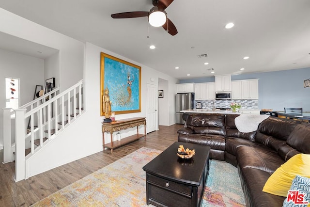 living room with ceiling fan and dark hardwood / wood-style flooring