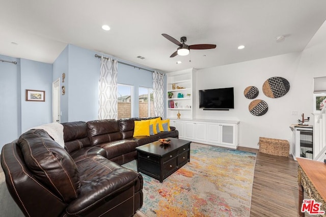 living room with ceiling fan, light hardwood / wood-style floors, and built in shelves