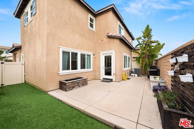 rear view of property with central air condition unit and a patio area