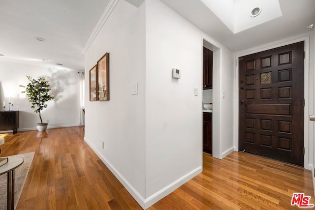 foyer entrance featuring ornamental molding and hardwood / wood-style floors