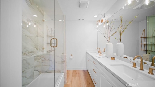 bathroom featuring vanity, wood-type flooring, and a shower with door