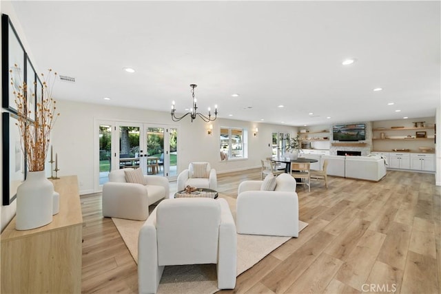 living room featuring a chandelier, french doors, and light hardwood / wood-style floors