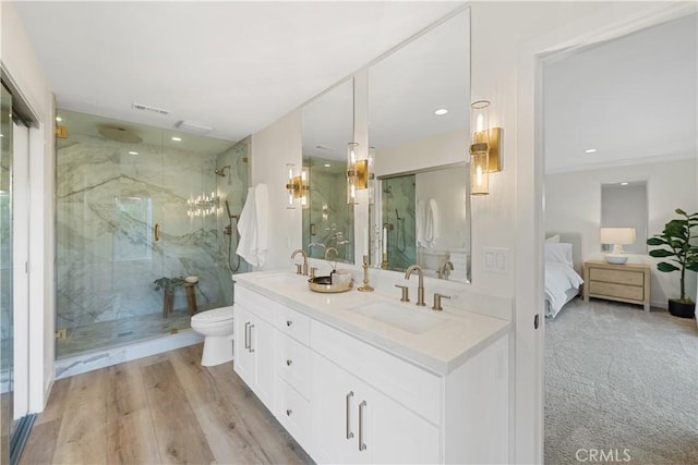 bathroom featuring toilet, hardwood / wood-style floors, vanity, and walk in shower