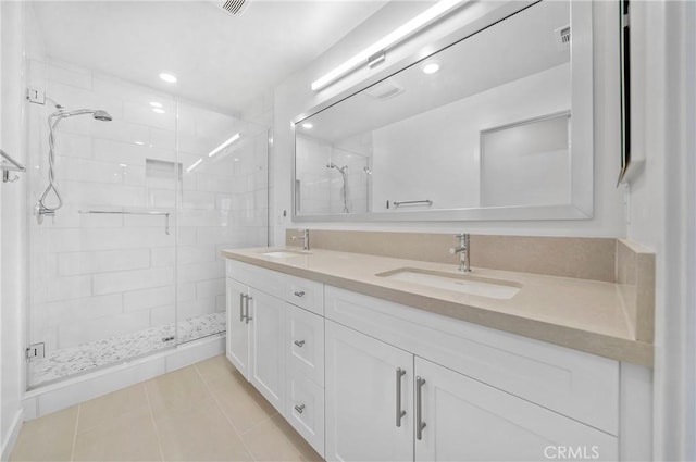 bathroom with a shower with door, vanity, and tile patterned floors