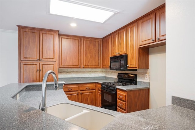 kitchen featuring sink, black appliances, stone counters, and tasteful backsplash