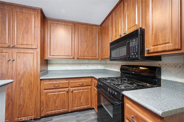 kitchen with light hardwood / wood-style floors, backsplash, and black appliances