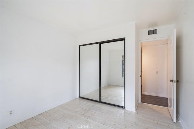 unfurnished bedroom featuring a closet and light hardwood / wood-style flooring