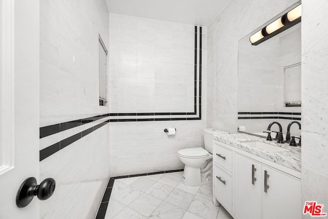 bathroom featuring tile walls, toilet, and vanity