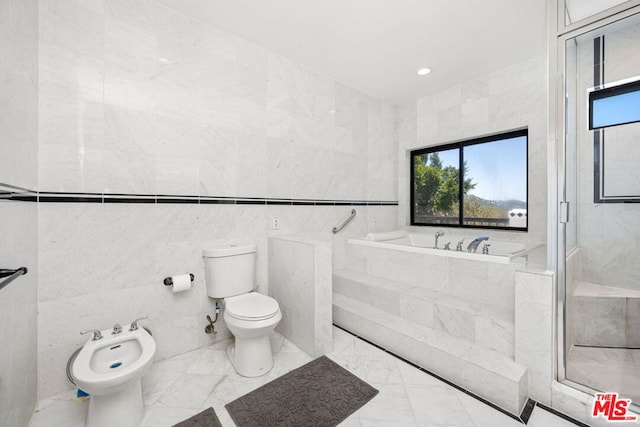 bathroom featuring toilet, tile walls, tiled tub, and a bidet