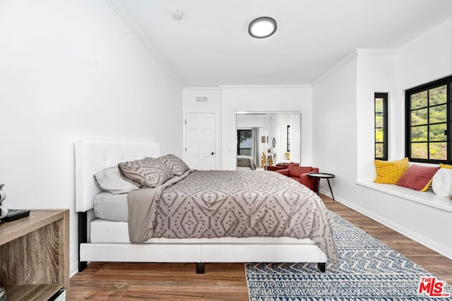 bedroom with hardwood / wood-style floors and ornamental molding