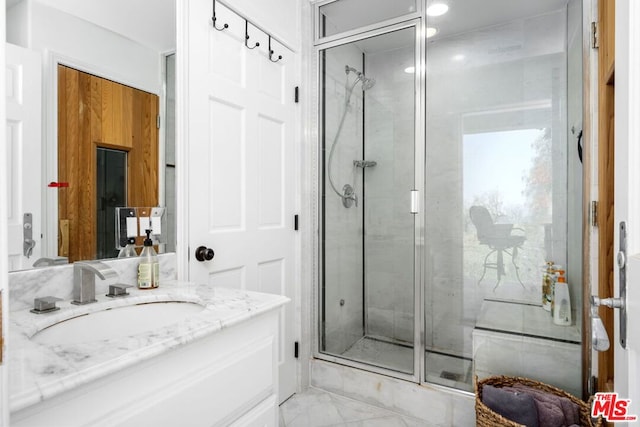 bathroom with a shower with shower door and vanity