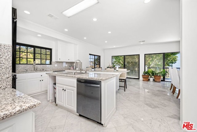 kitchen with a center island with sink, dishwasher, white cabinets, light stone counters, and sink