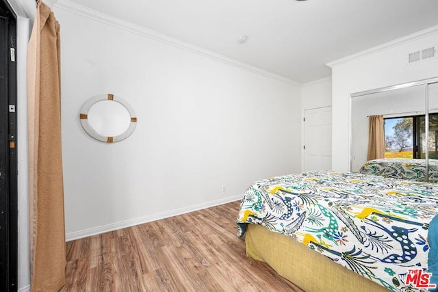 bedroom featuring crown molding and hardwood / wood-style floors