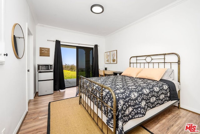 bedroom featuring wood-type flooring, crown molding, and access to outside