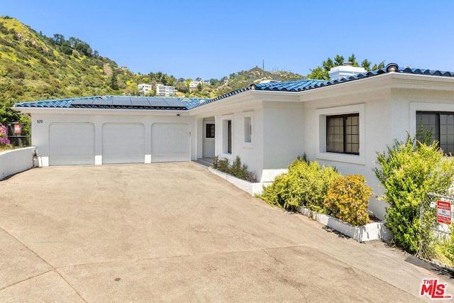 view of front of home with a garage and solar panels