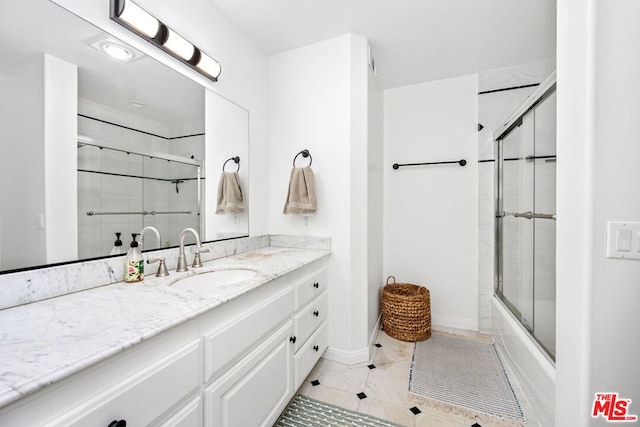 bathroom with bath / shower combo with glass door, tile patterned floors, and vanity