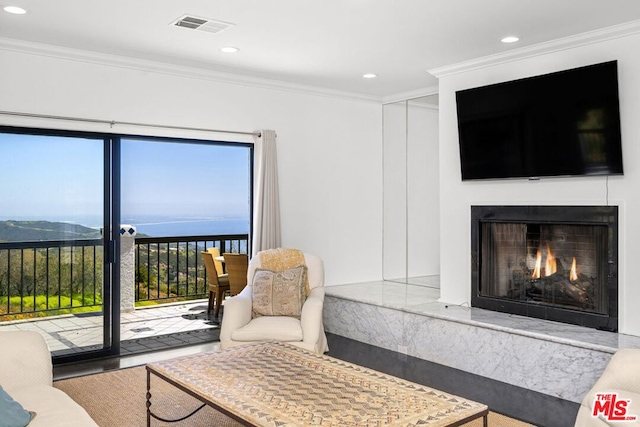 living room with a high end fireplace and crown molding