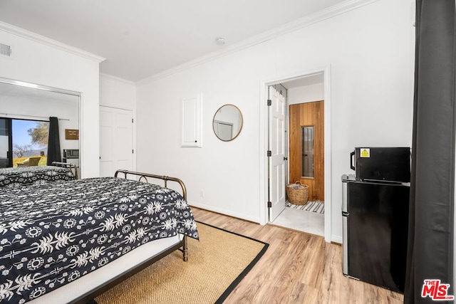 bedroom with ensuite bath, refrigerator, crown molding, and light hardwood / wood-style floors