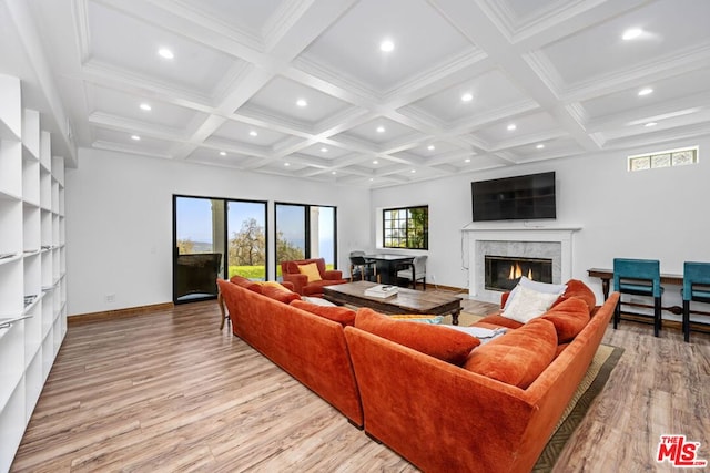 living room with a fireplace, light hardwood / wood-style floors, beam ceiling, and coffered ceiling