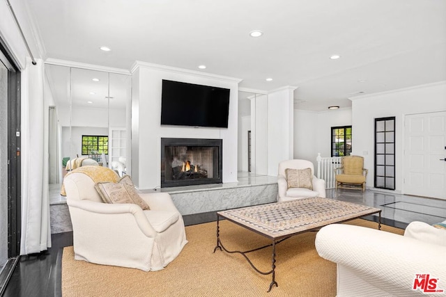 living room featuring a high end fireplace and crown molding