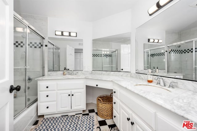 bathroom featuring bath / shower combo with glass door and vanity