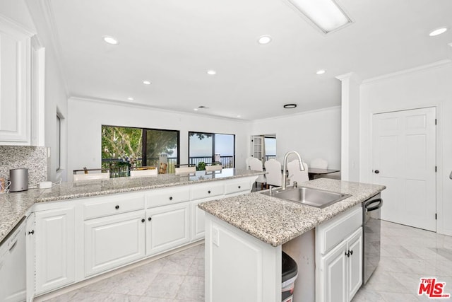 kitchen featuring sink, white cabinets, dishwasher, and an island with sink