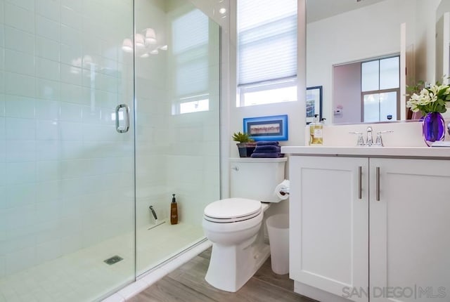 bathroom with an enclosed shower, wood-type flooring, vanity, toilet, and a notable chandelier