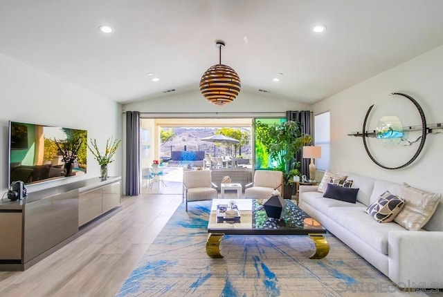 living room with light hardwood / wood-style floors and lofted ceiling