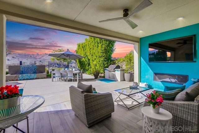 view of patio / terrace featuring ceiling fan, exterior kitchen, outdoor lounge area, and a grill