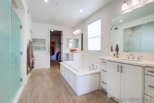 bathroom featuring shower with separate bathtub and vanity