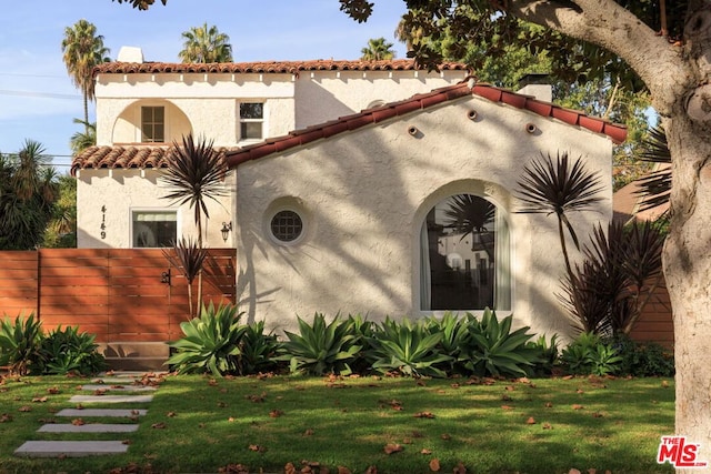 mediterranean / spanish-style home featuring a front yard