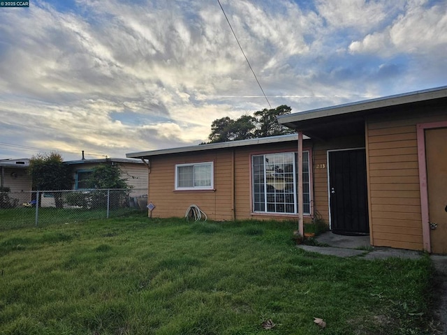 back house at dusk with a lawn