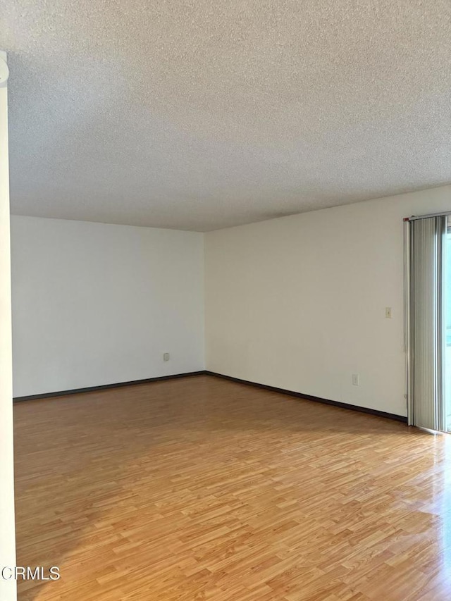 spare room featuring a textured ceiling and light wood-type flooring