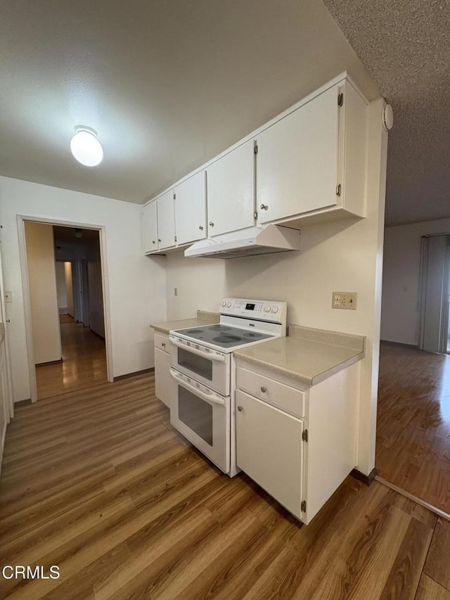 kitchen featuring dark hardwood / wood-style floors, white cabinetry, and white electric range oven