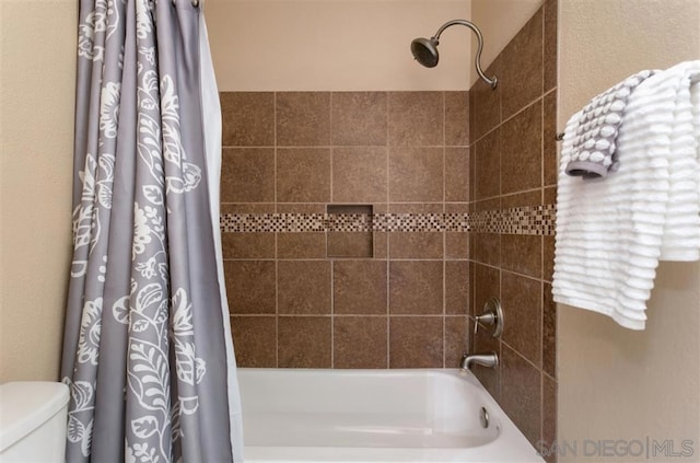 bathroom with toilet and shower / tub combo with curtain