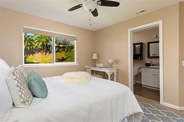 tiled bedroom with ceiling fan and ensuite bathroom