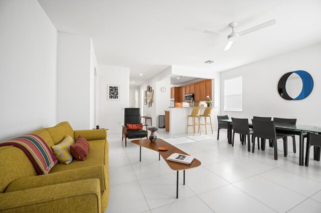 tiled living room with ceiling fan