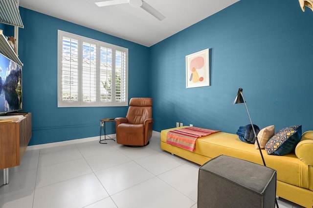 sitting room featuring light tile patterned flooring and ceiling fan