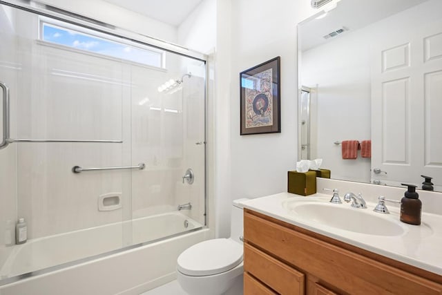 full bathroom featuring vanity, bath / shower combo with glass door, and toilet