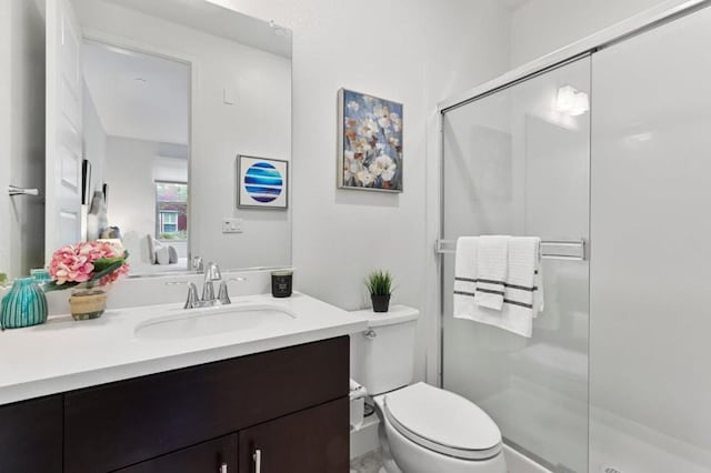 bathroom featuring toilet, a shower with door, and vanity