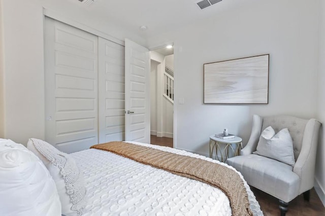 bedroom with dark wood-type flooring and a closet